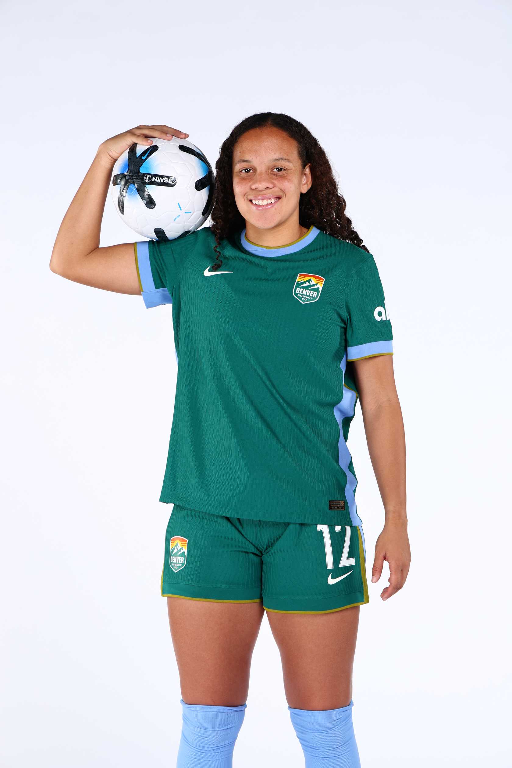 Person wearing a green sports uniform holding a soccer ball on a white background